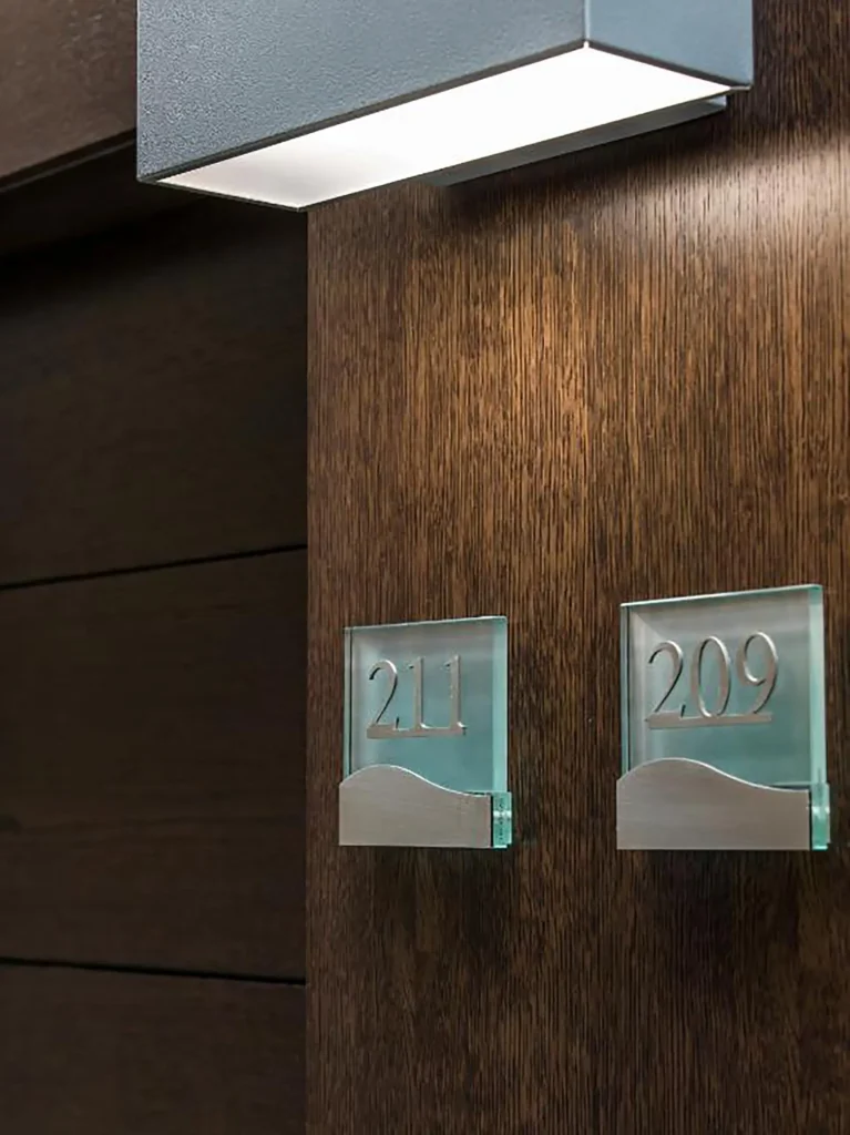 Nell'immagine di mostrano le porte contrassegnate con i numeri 211 e 209 e illuminate da lampade